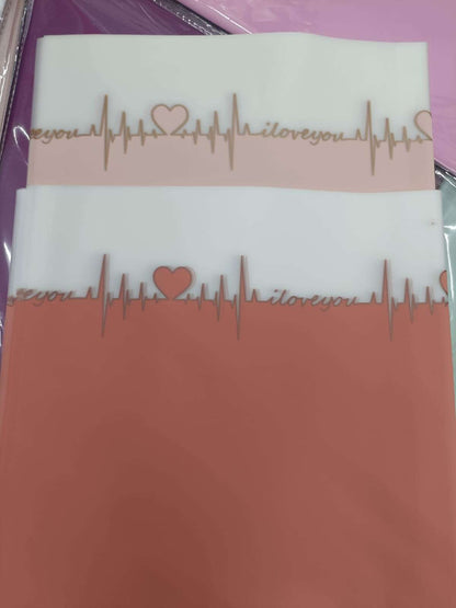 Two wrapping paper sheets, blue and orange, with gold ECG line and heart pattern
