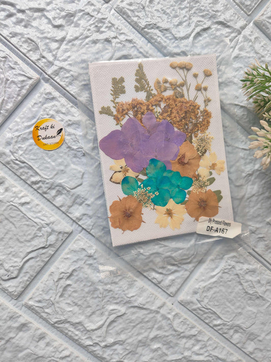 Compressed Flower Sheet Mix A1 with purple, teal and brown dried blooms on paper