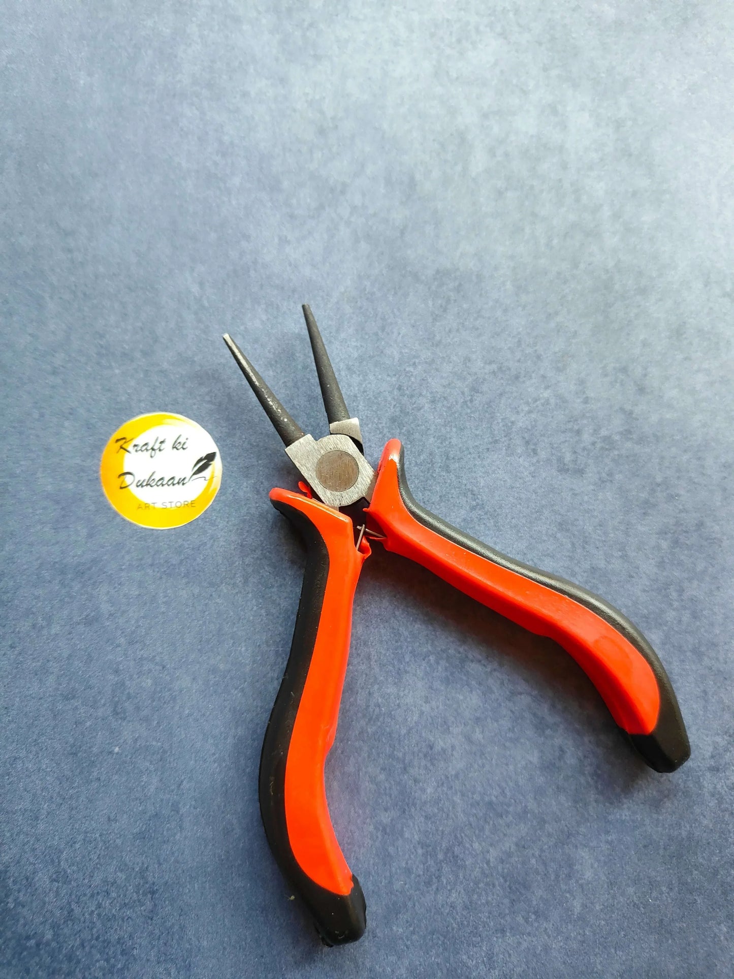 Orange-handled pliers with two metal jaws and cutting edges