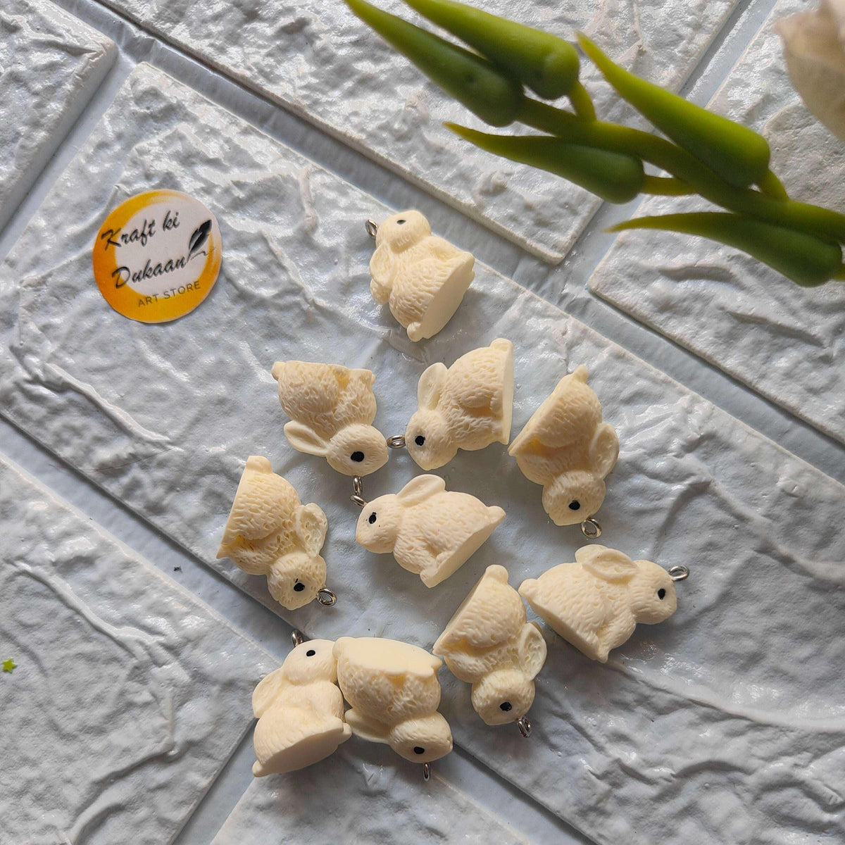 Rabbit charm pendants set (10) in off-white; each rabbit with small metal loop