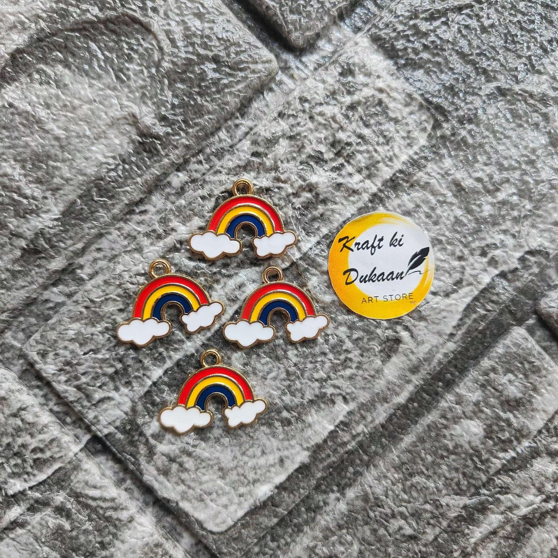 Rainbow metal charm set: four small rainbow-and-cloud pendants with gold loops