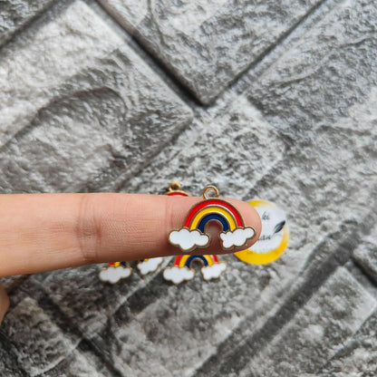 Rainbow metal charm with red-yellow-blue arc and white cloud detail, held in hand