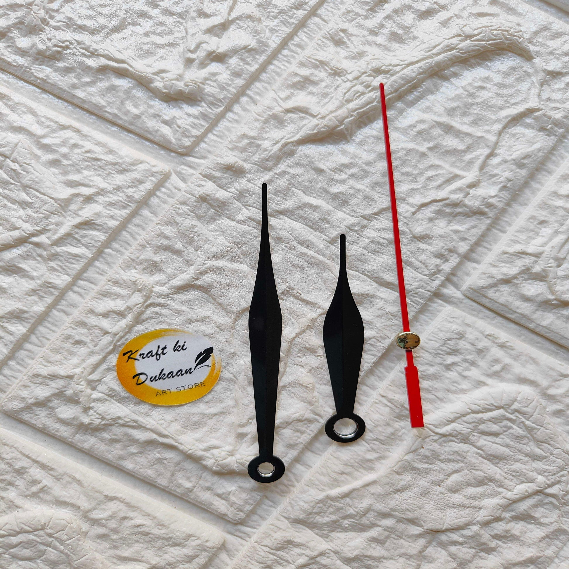 Red and black metal clock hands set with gold tips, C1 design