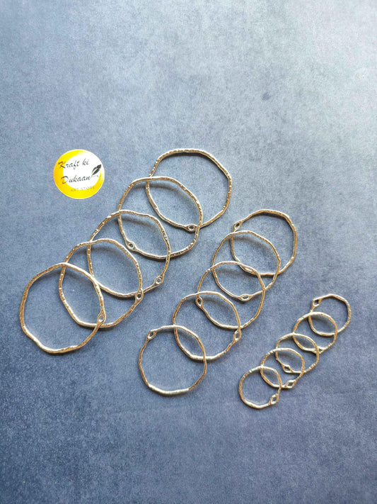 Gold round bezel settings with layered circular rings and small connector loops