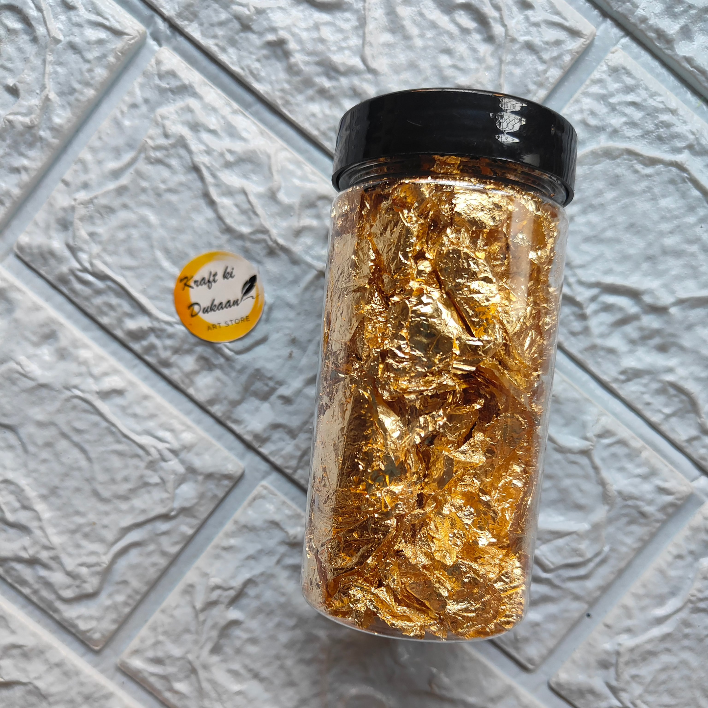 Jar of golden resin art foil flakes for crafting and decoration projects
