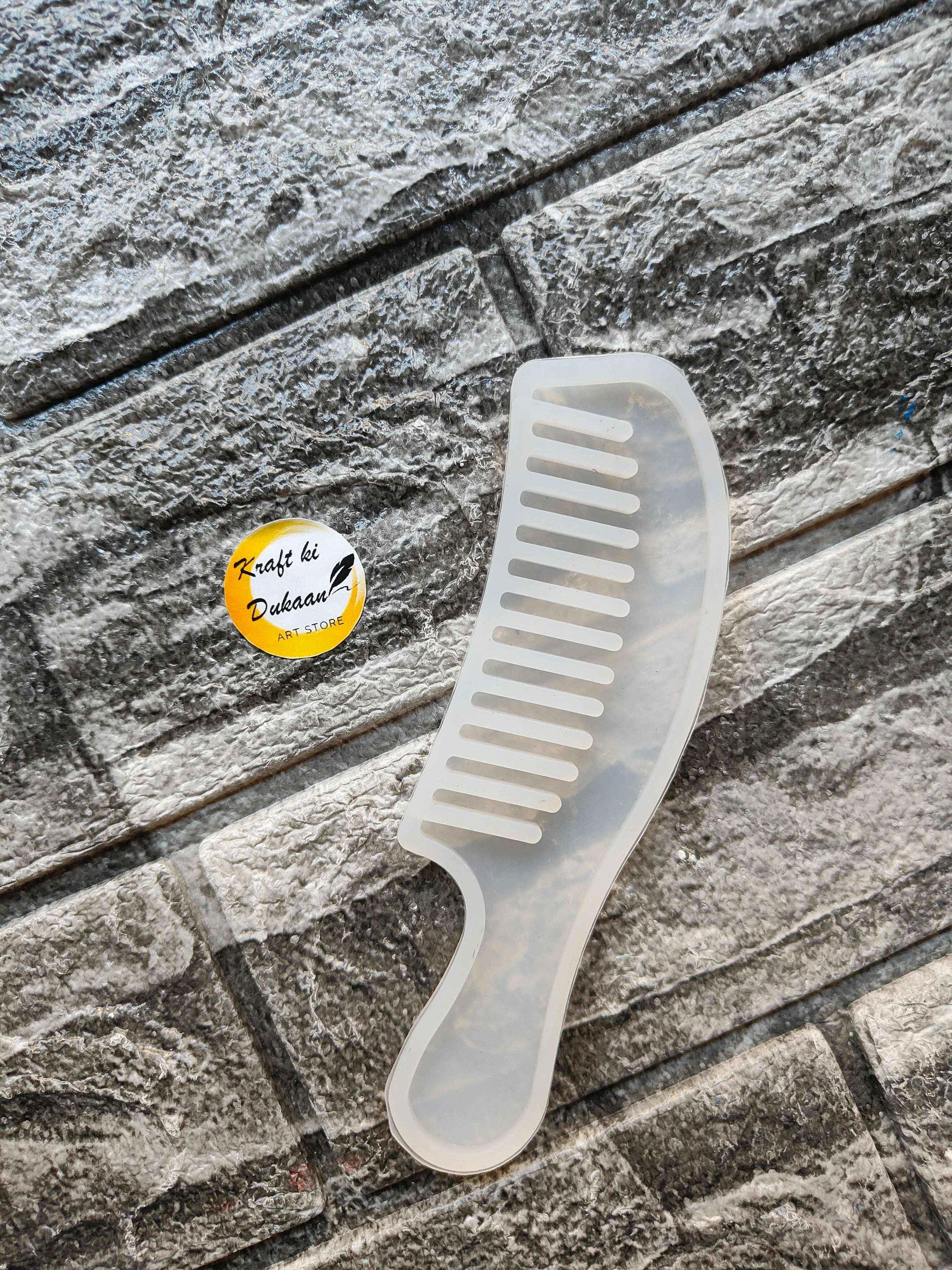 Comb mould C: white plastic comb with rounded handle and evenly spaced teeth