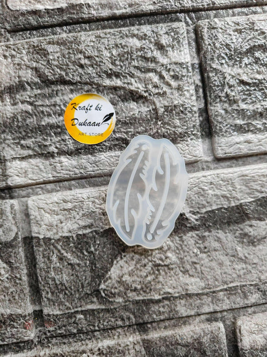 Earring mould A3 translucent light-blue plastic, oval frame with feather-like cuts.
