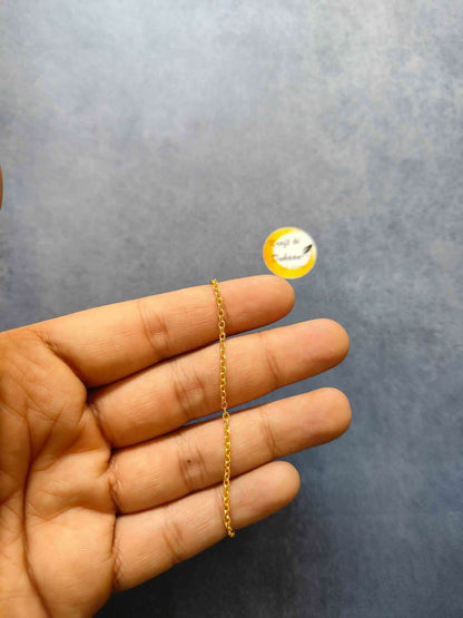 Gold short chain necklace, single small-link chain held in hand