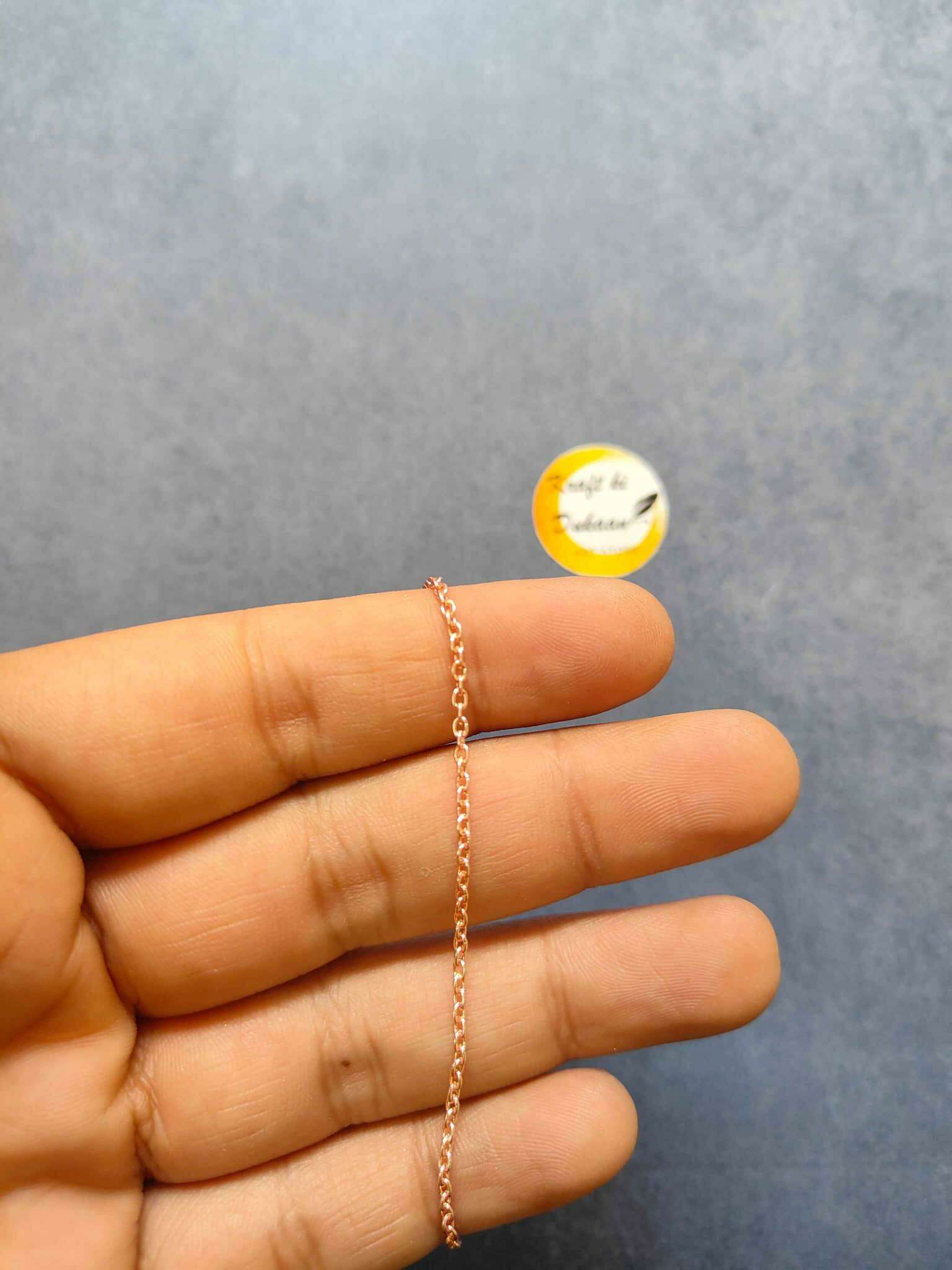 Rose gold short chain necklace, single small-link chain held in hand