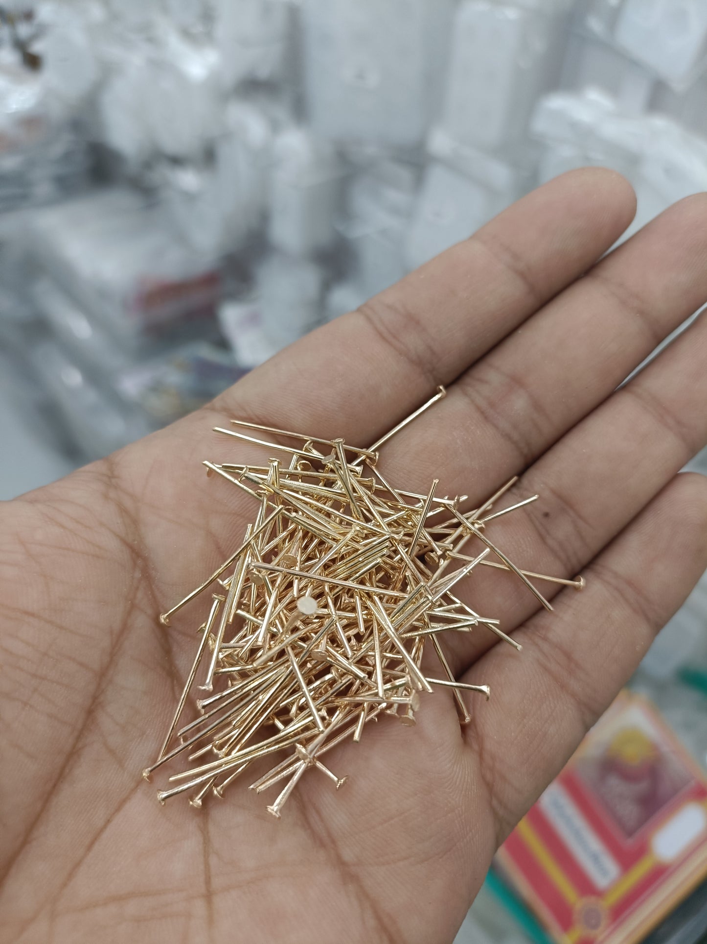 Gold jewellery head hook pins, long needles in palm