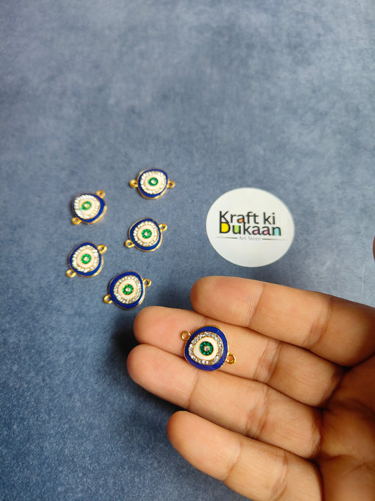 Rakhi bracelet pendant, blue enamel ring, green center, gold loop held in hand