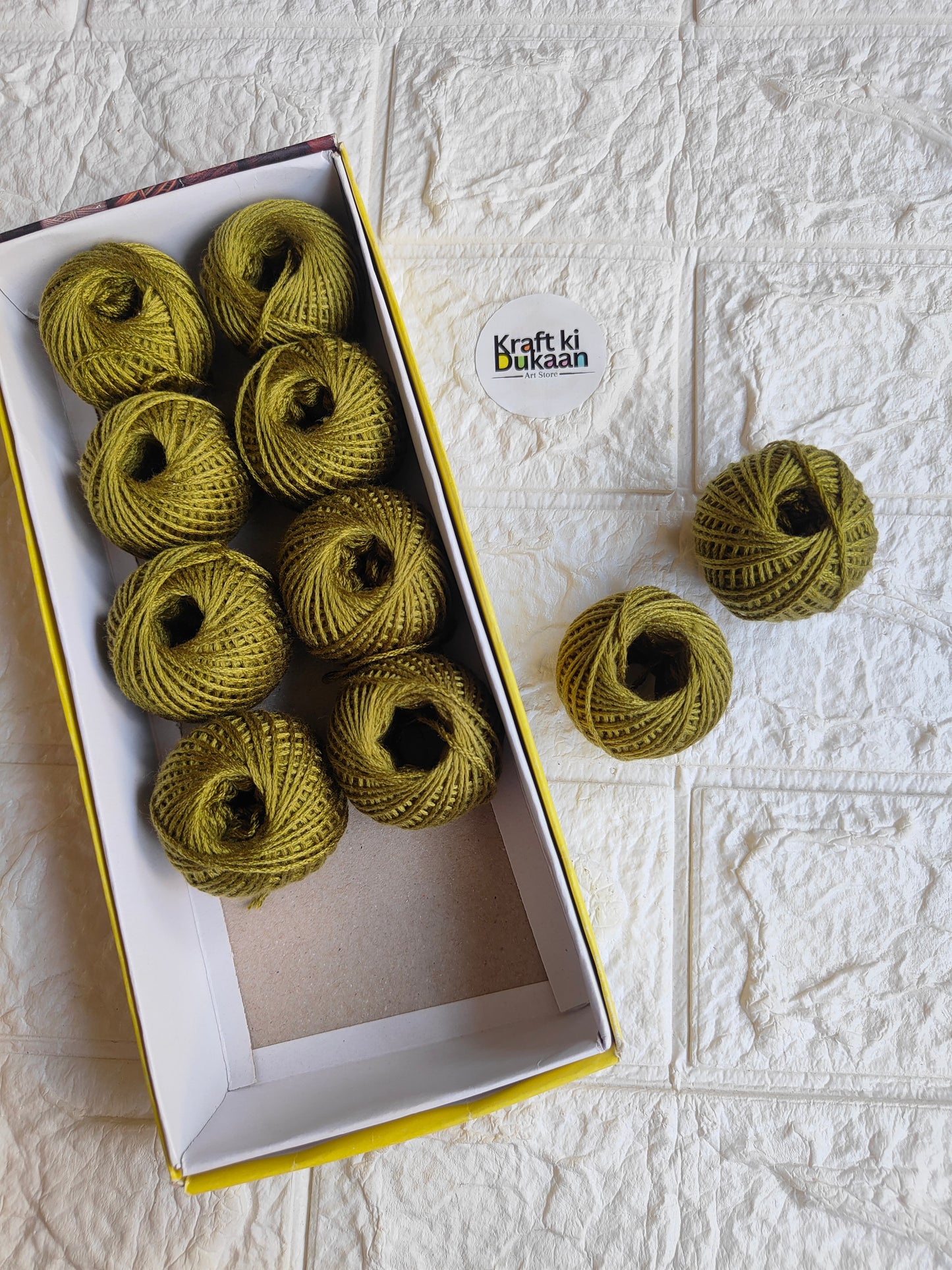 Rakhi thread roll with olive green thread balls in open box and loose ball