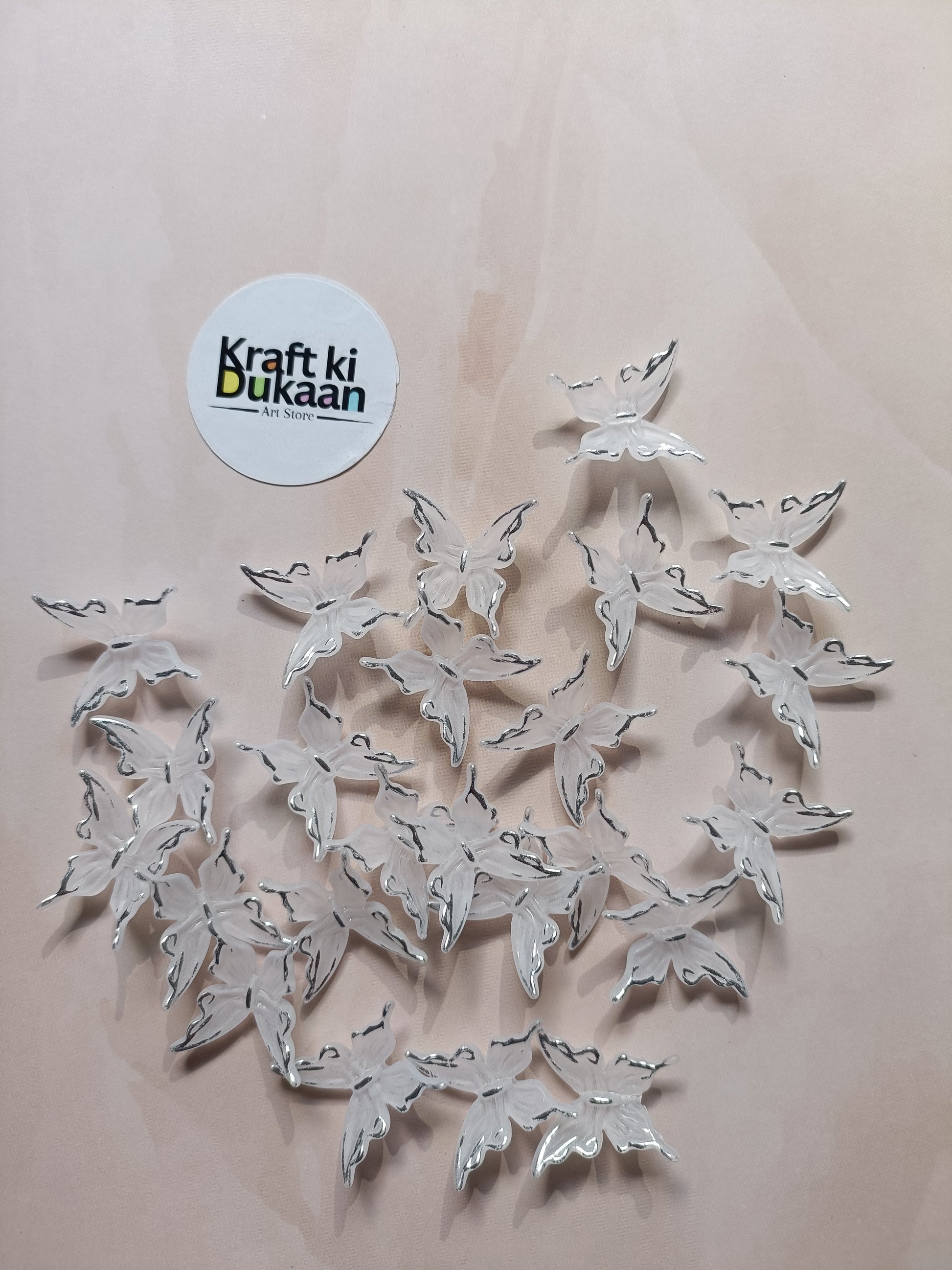 Silver butterfly beads scattered on background with metal loops