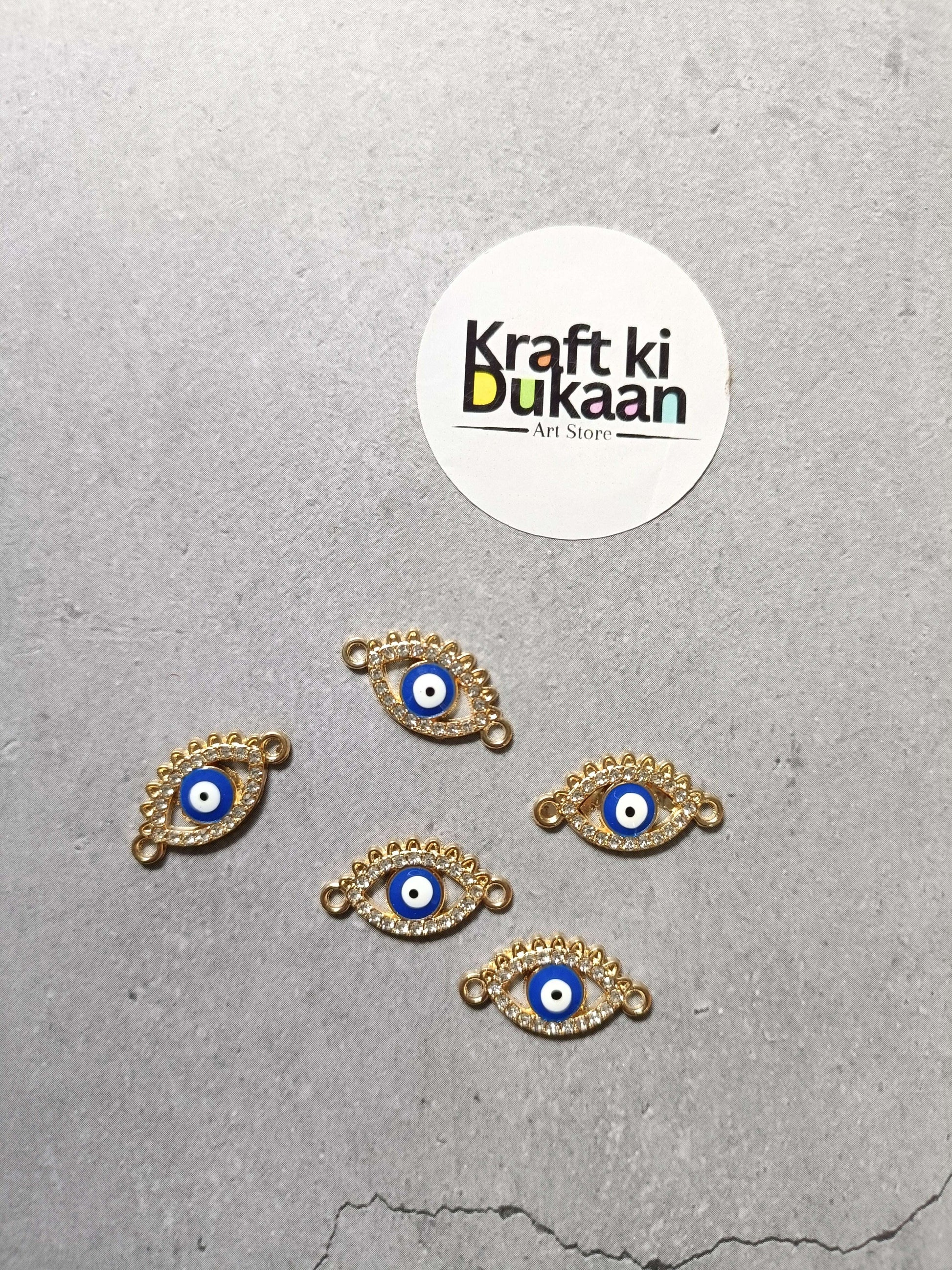 Gold-tone evil eye bracelet charms set of five, laid out