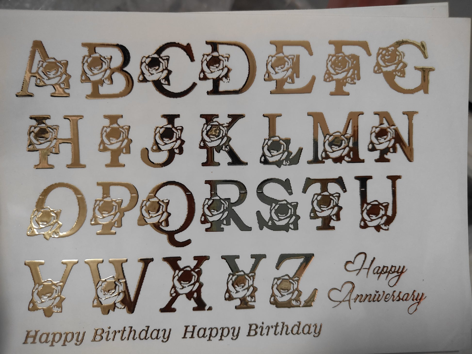 Gold embossed sticker sheet with cartoon letter icons and Happy Birthday text