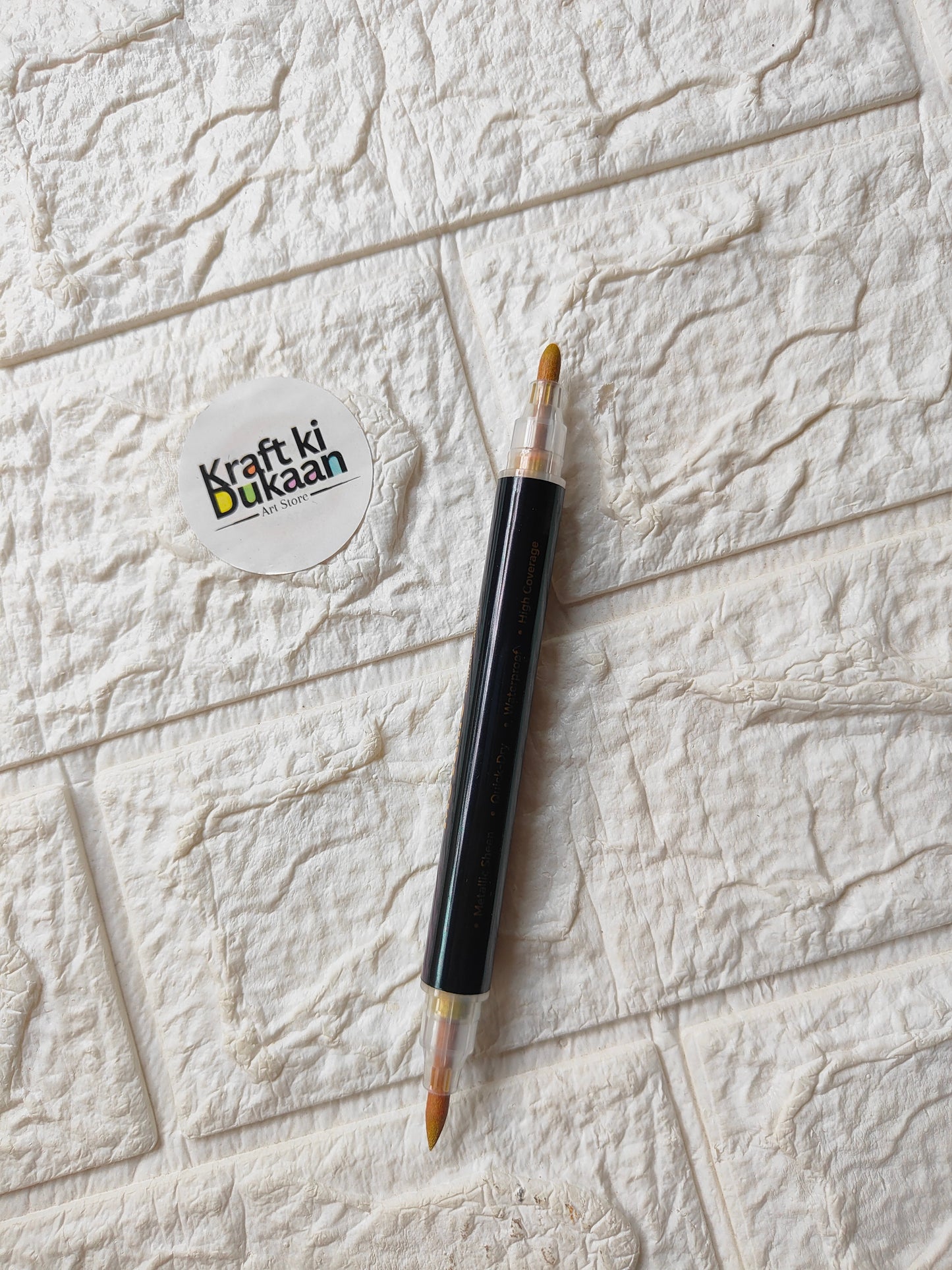 Single dual-tip metallic acrylic marker in gold with visible nib