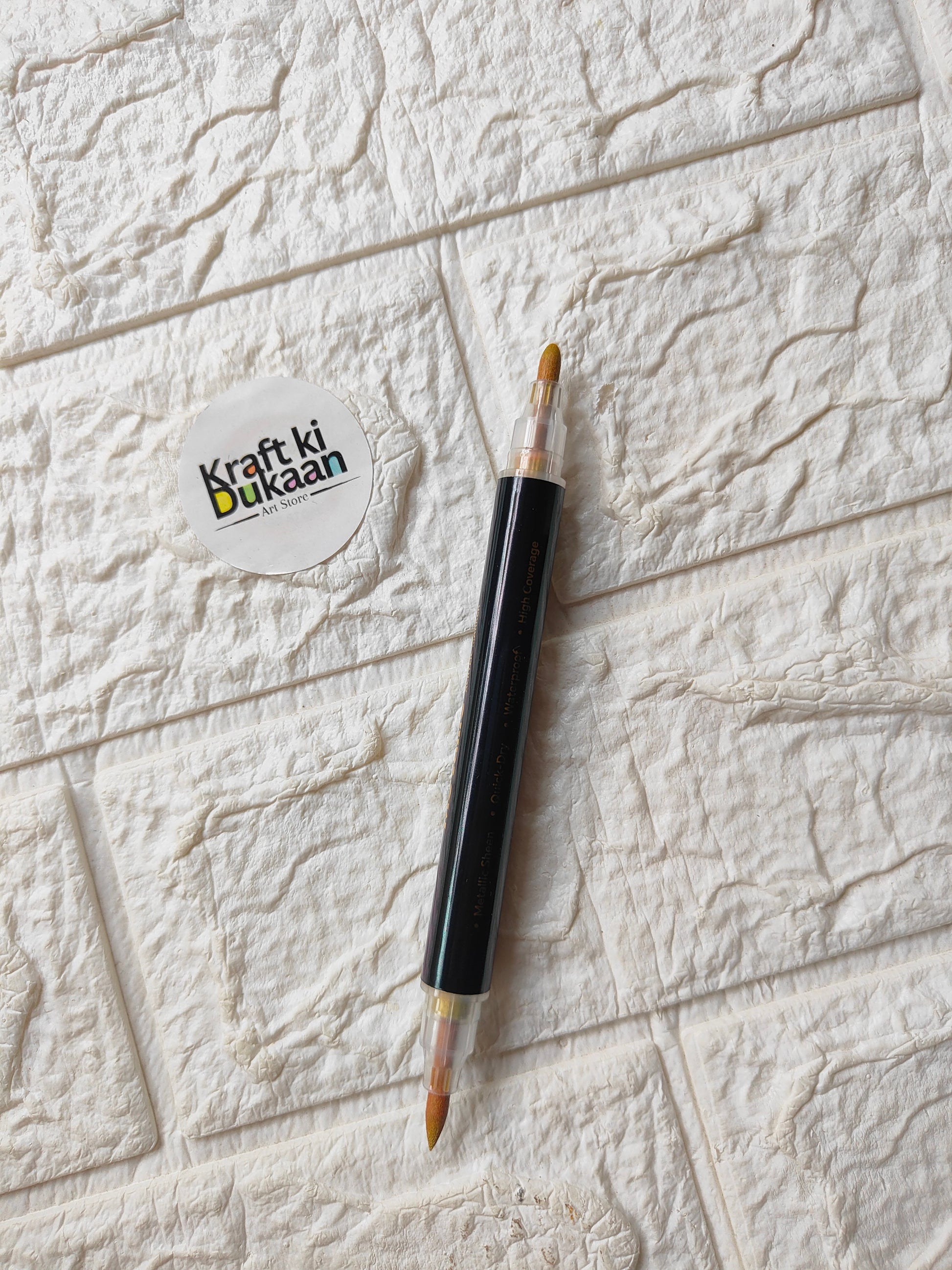 Single dual-tip metallic acrylic marker in gold with visible nib