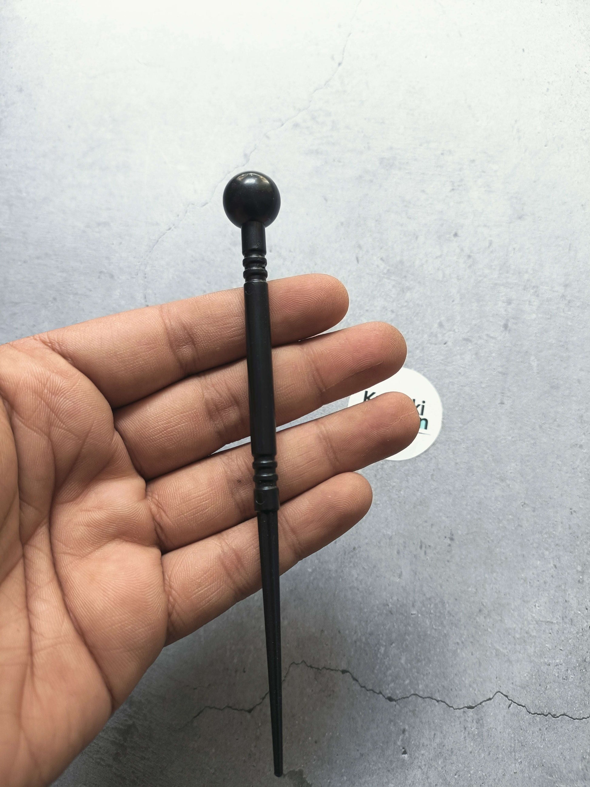 Black clay modelling ball stylus tool in hand