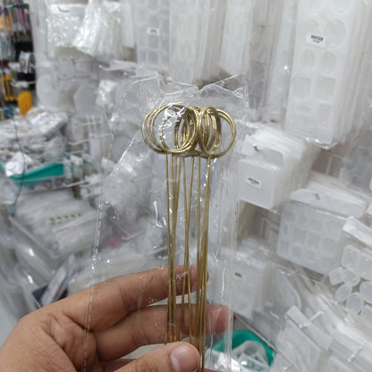 Set of gold metal round place card holders with loop tops held in hand