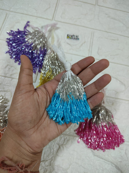Set of 10 metallic latkan tassels held in hand: blue, silver, with purple and pink tassels