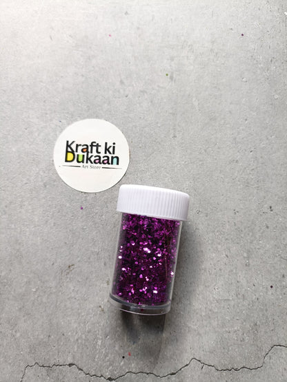 Hexagon glitter jar with purple glitter in a small white-lidded bottle