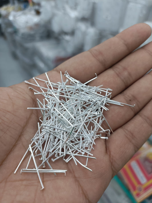 Silver jewellery head hook pins, scattered in palm
