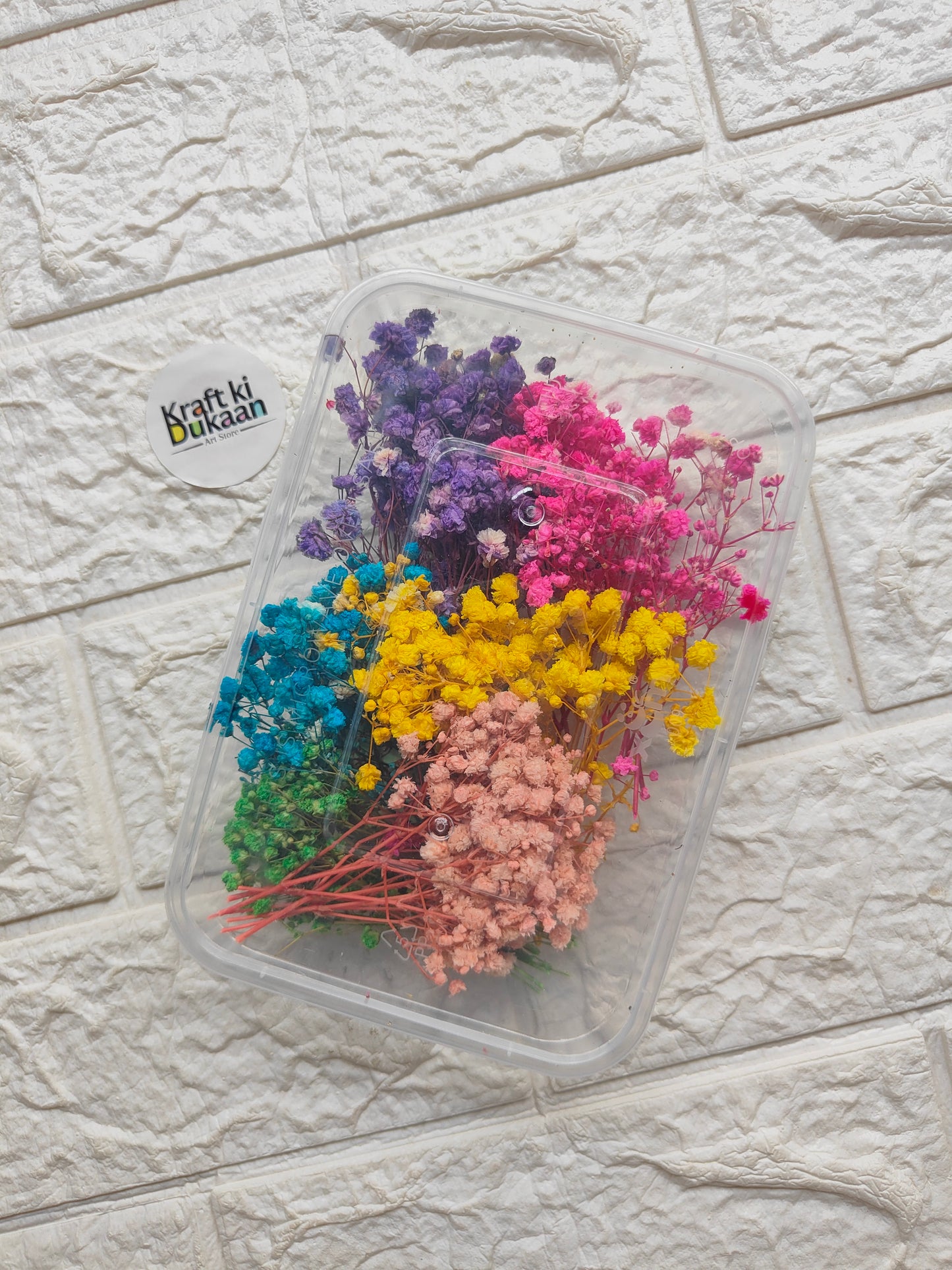 Rounded clear plastic flower box filled with mixed dried flowers: purple, pink, blue, yellow, peach