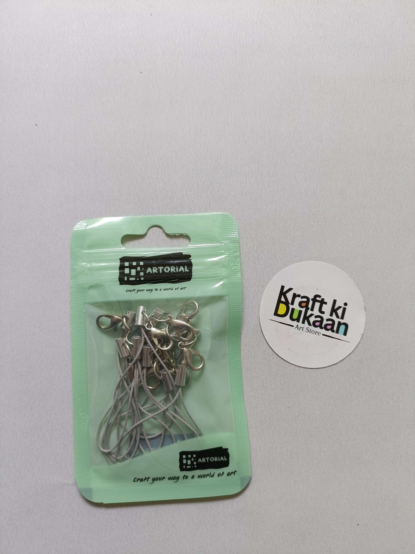 Green cord keychain set with lobster clasps, metal clips on a card pack.