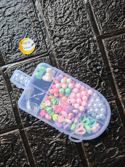 DIY bracelet beads kit: clear container of pastel beads, green and pink, plus white pearls