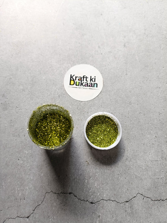 Olive green chunky glitter powder jar with small open cup.