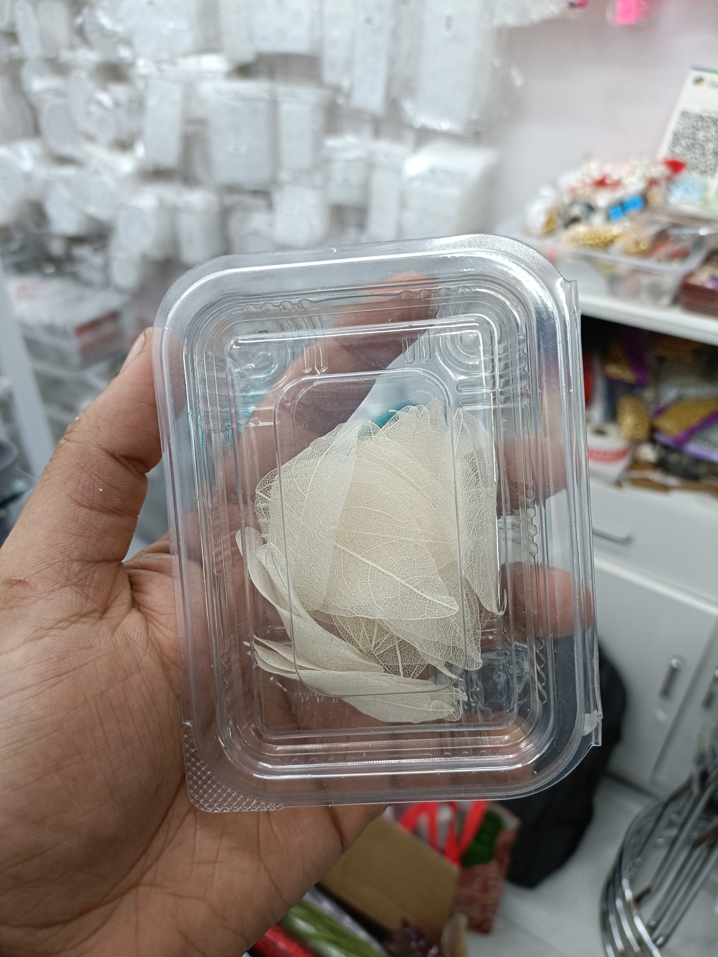 White leaf paper pieces in a clear plastic box