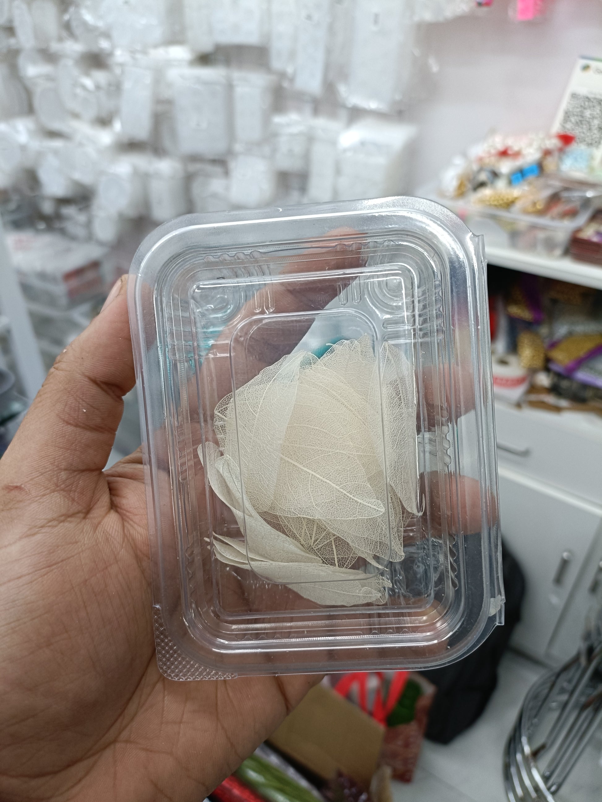 White leaf paper pieces in a clear plastic box