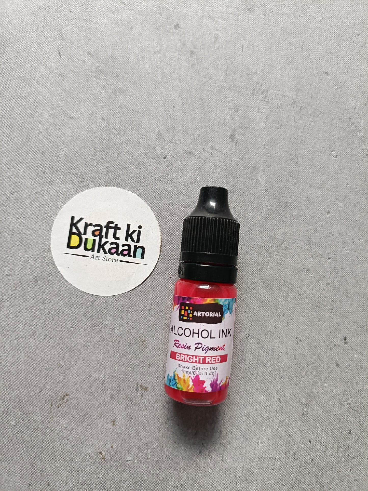 Alcohol ink bottle with black cap, bright red resin pigment label