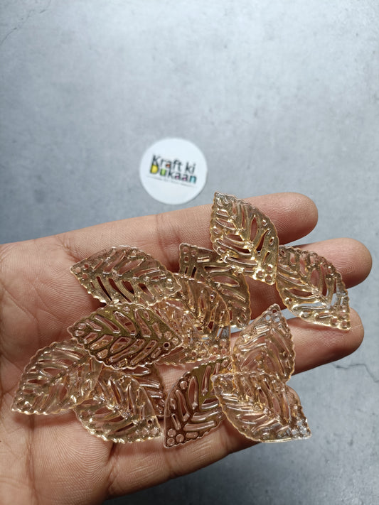 Gold leaf-shaped bead charms in hand, pack of 50