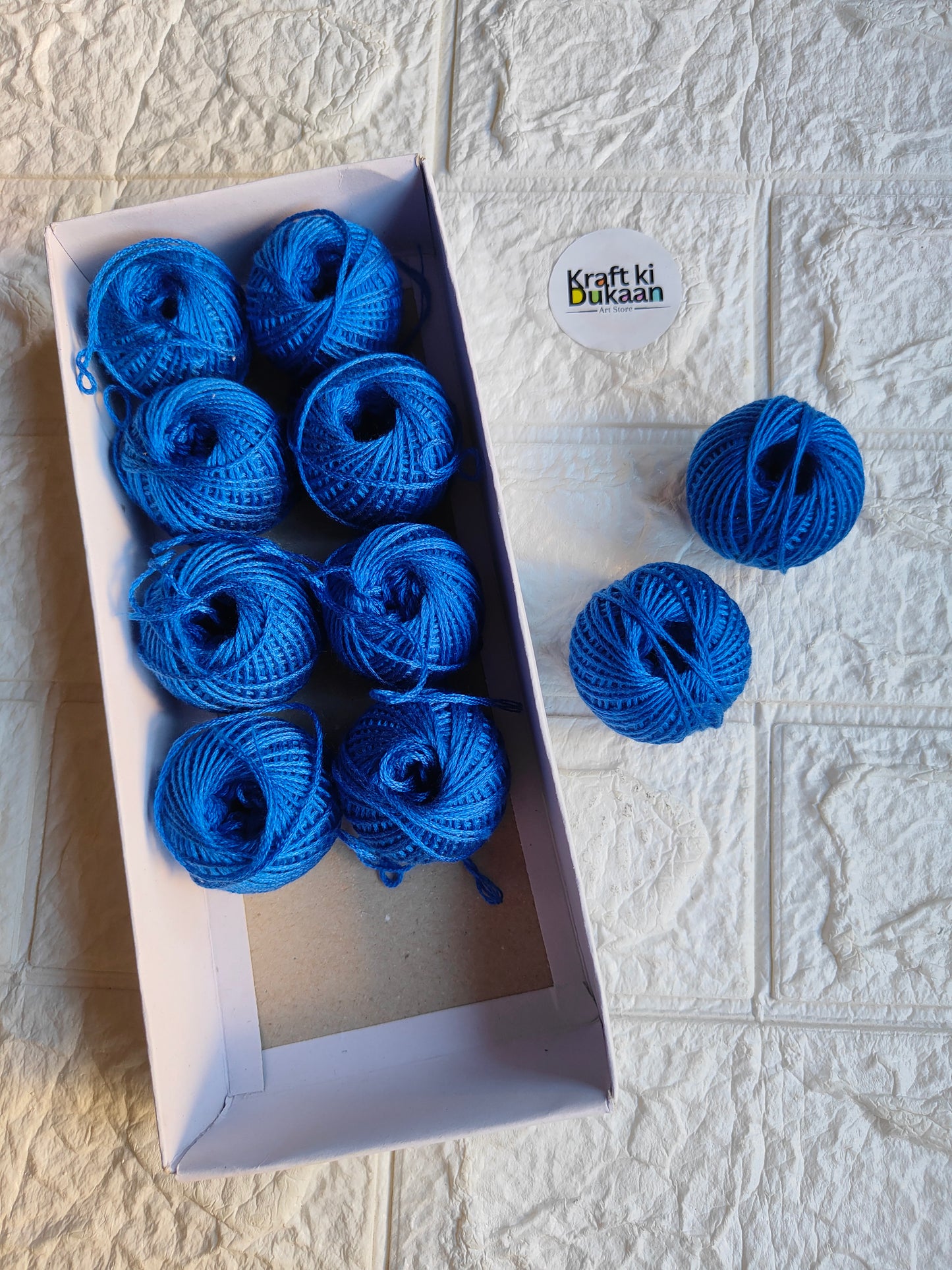 Rakhi thread roll set with blue yarn balls in an open cardboard box