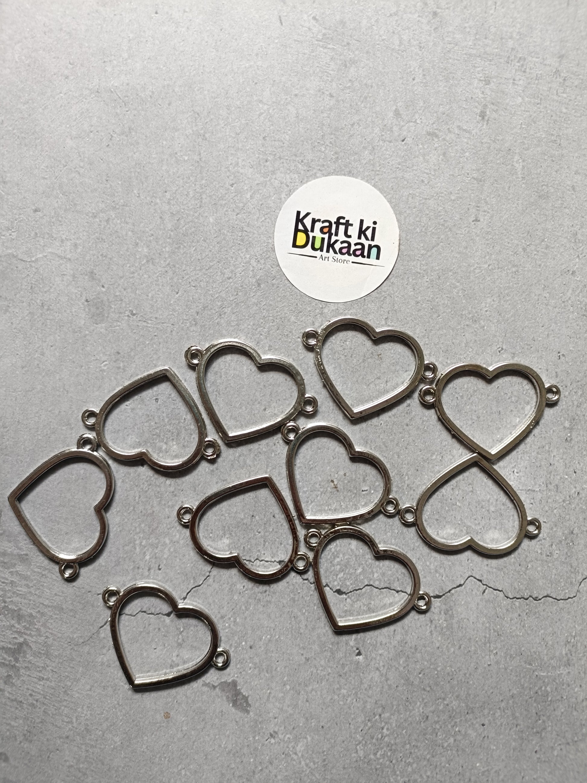 Set of silver-tone heart bezel charm bracelets, several hearts laid flat