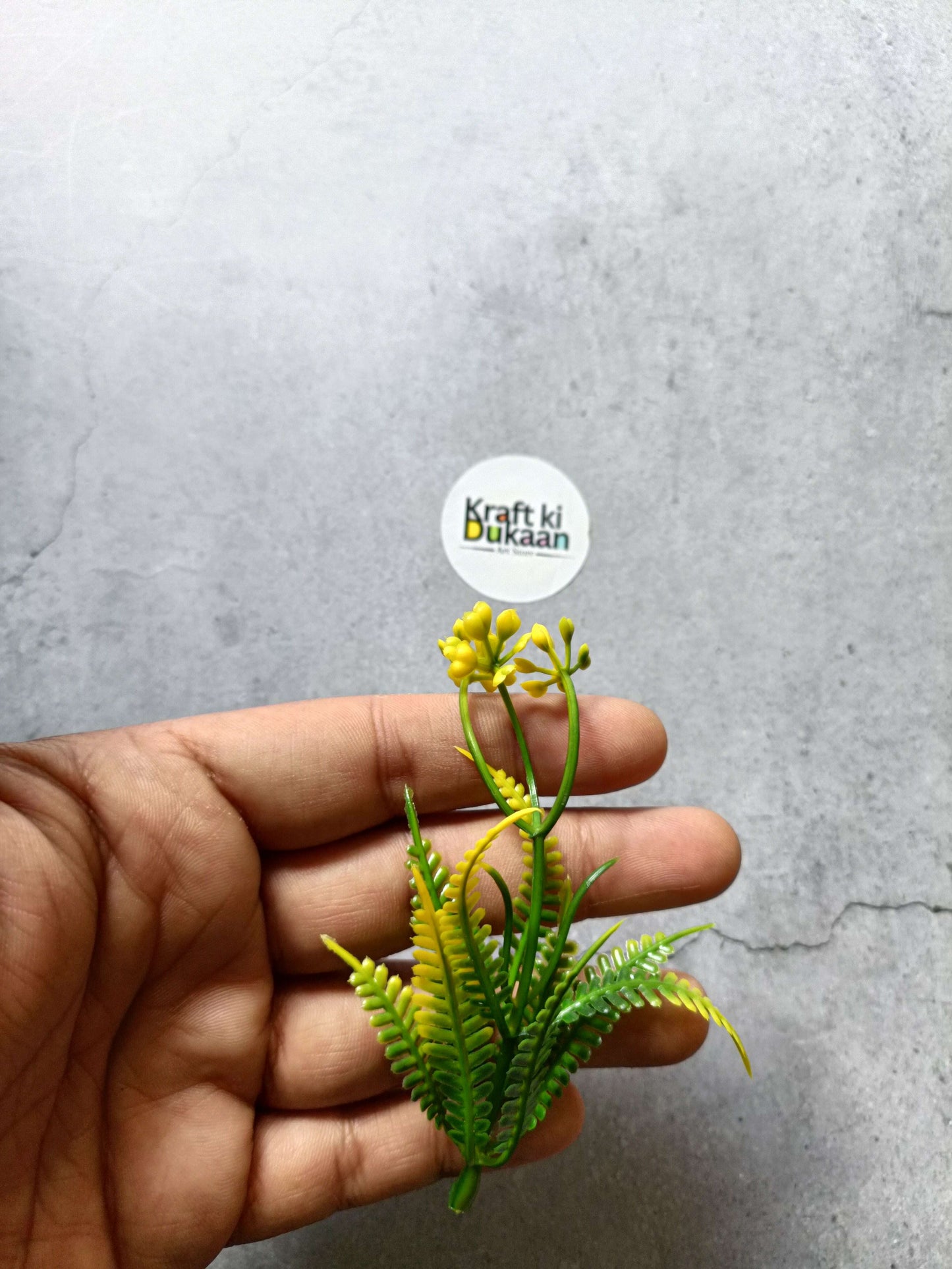 Artificial flower bunch pack of 5: yellow buds with green foliage, held in hand