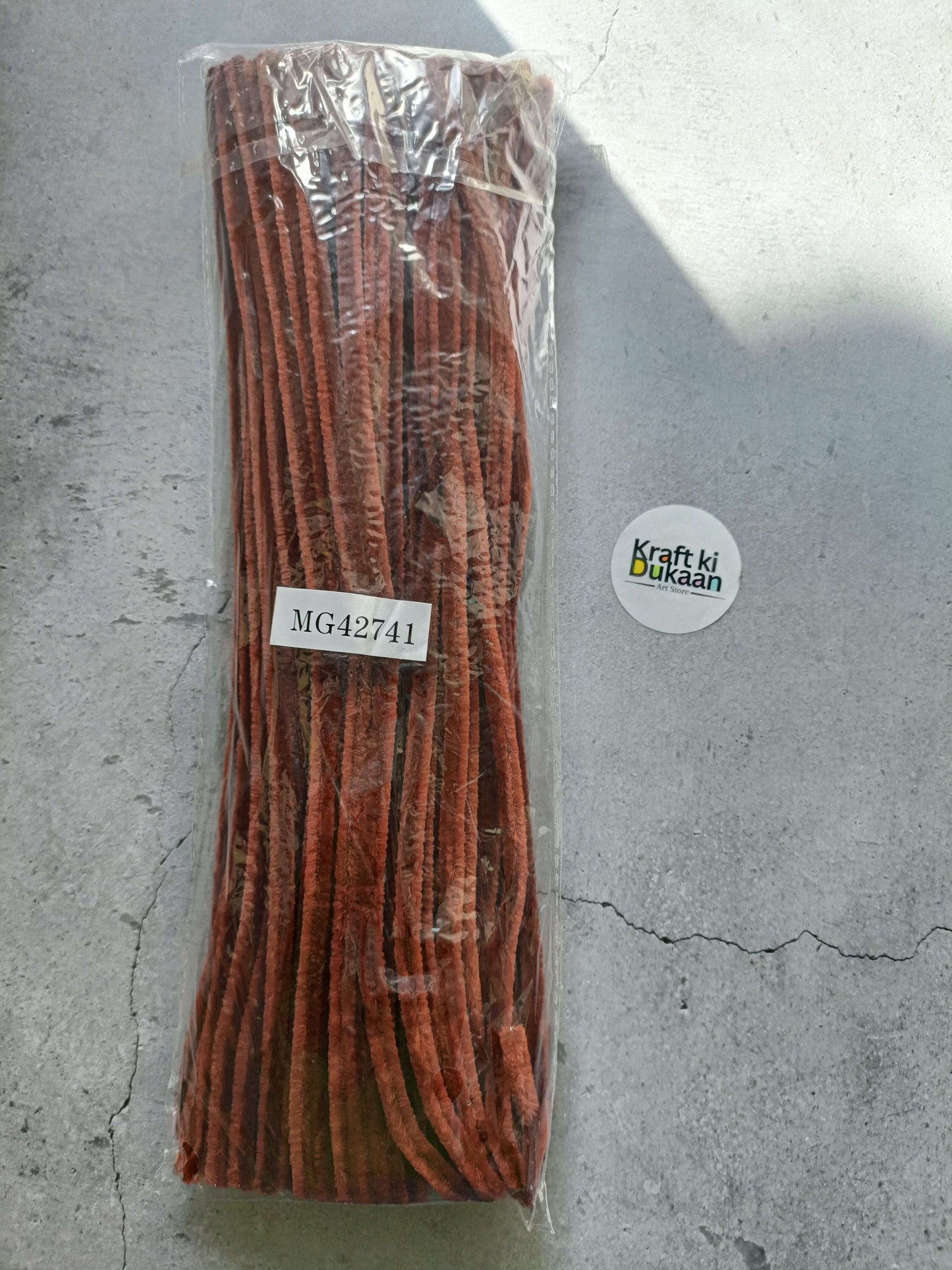 Chocolate brown pipe cleaners bundle in clear packaging, fuzzy chenille texture.