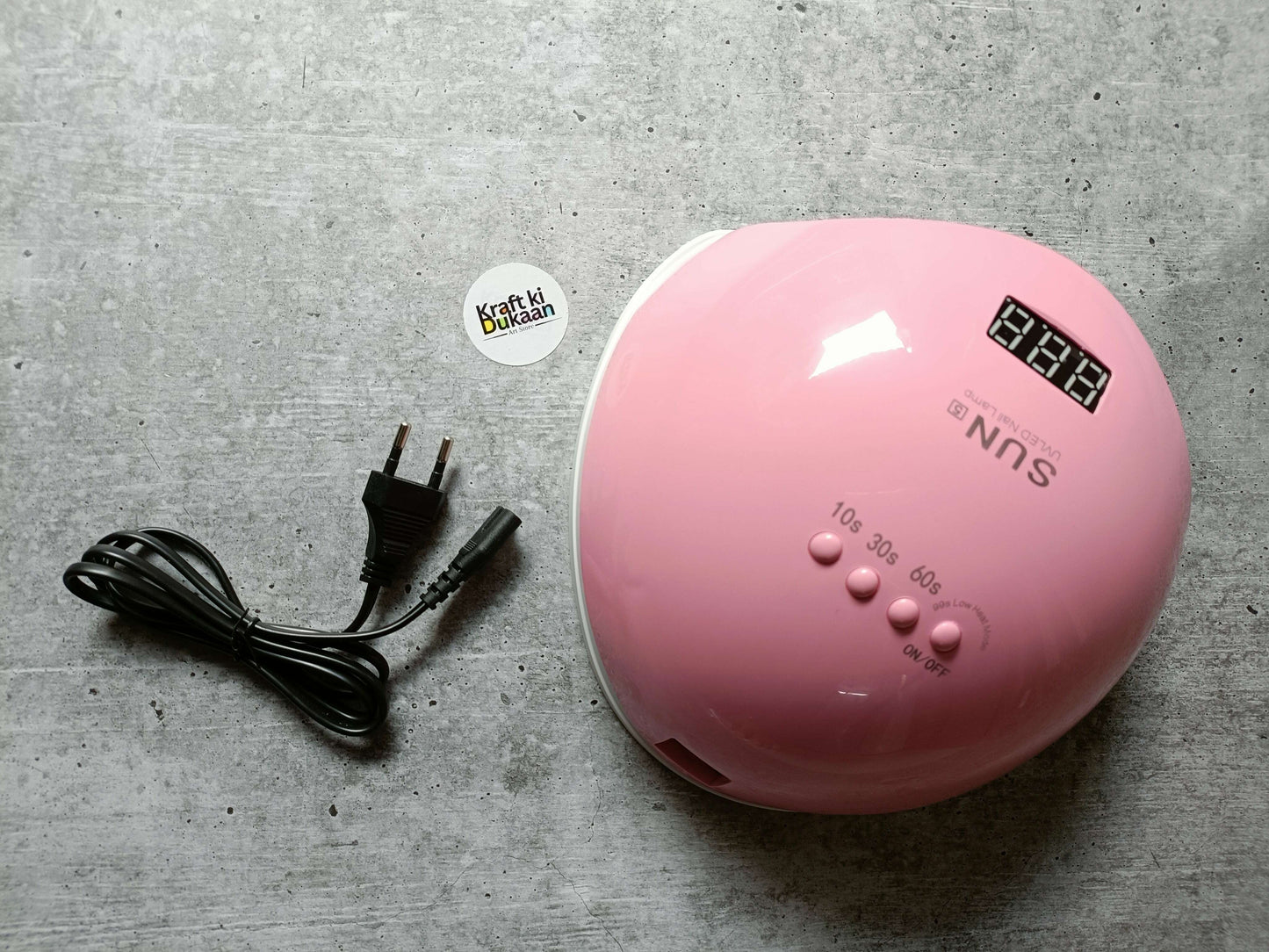 Pink UV LED nail lamp shown from front with digital display and labeled settings