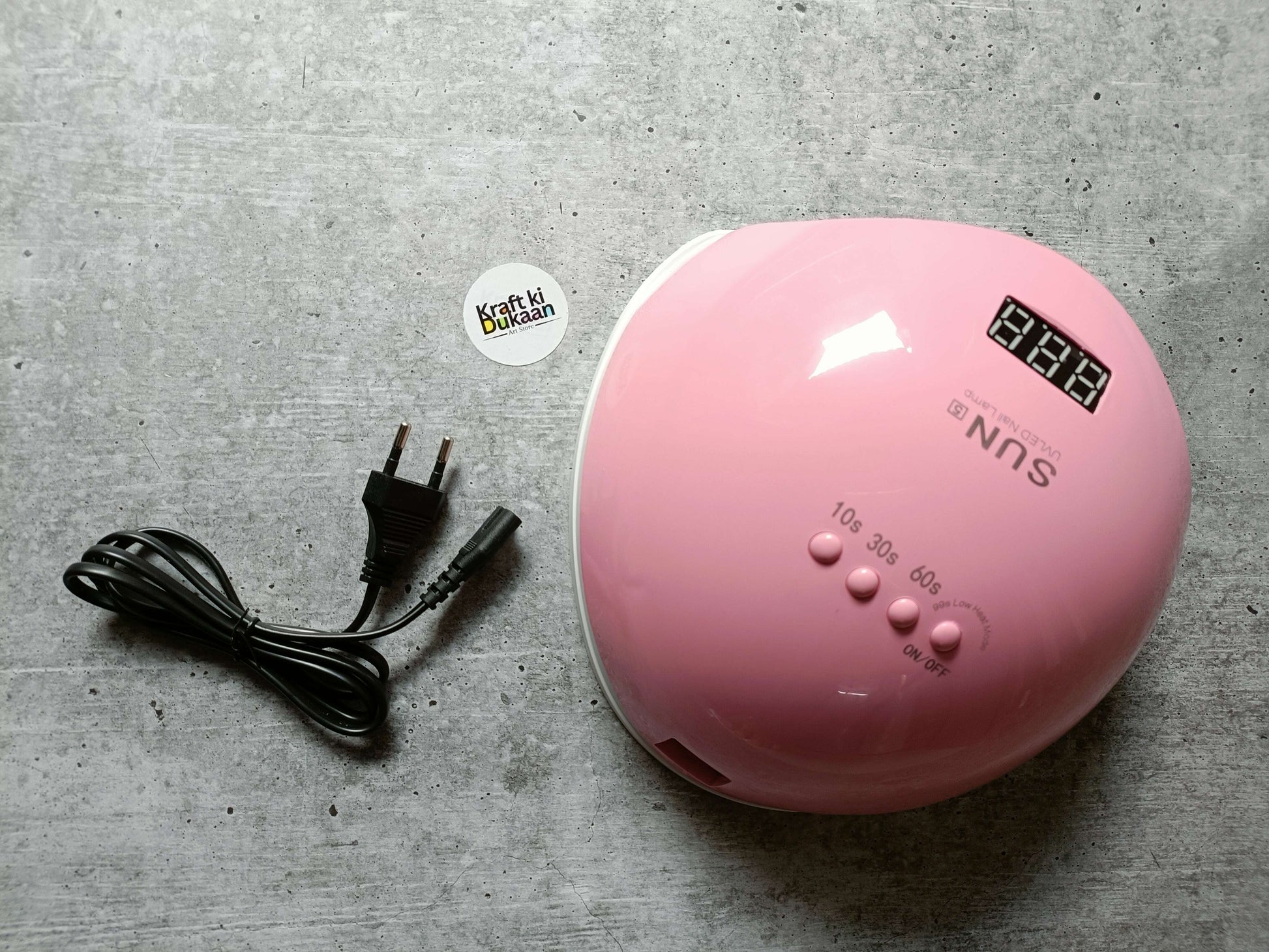 Pink UV LED nail lamp shown from front with digital display and labeled settings
