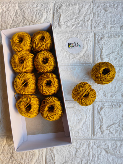 Rakhi thread roll with yellow-gold yarn balls in an open box and one loose ball