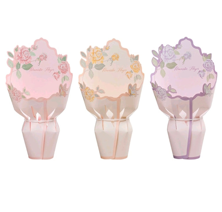 Three pastel floral cardboard flower wraps, pink, peach, and purple, scalloped design