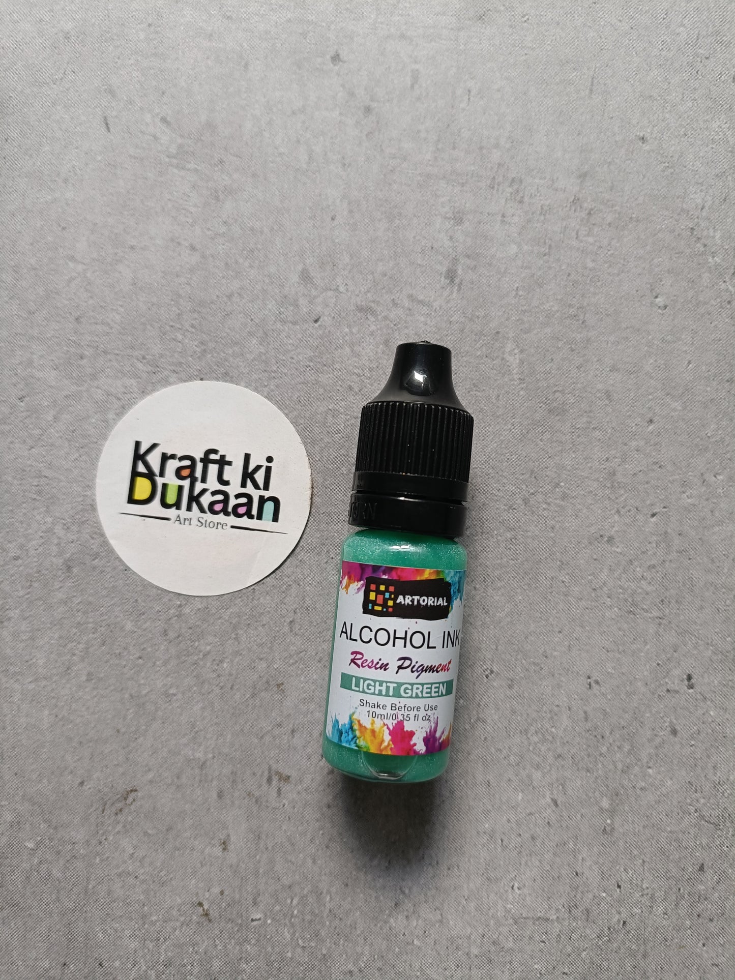 Alcohol ink bottle with black cap, light green resin pigment label