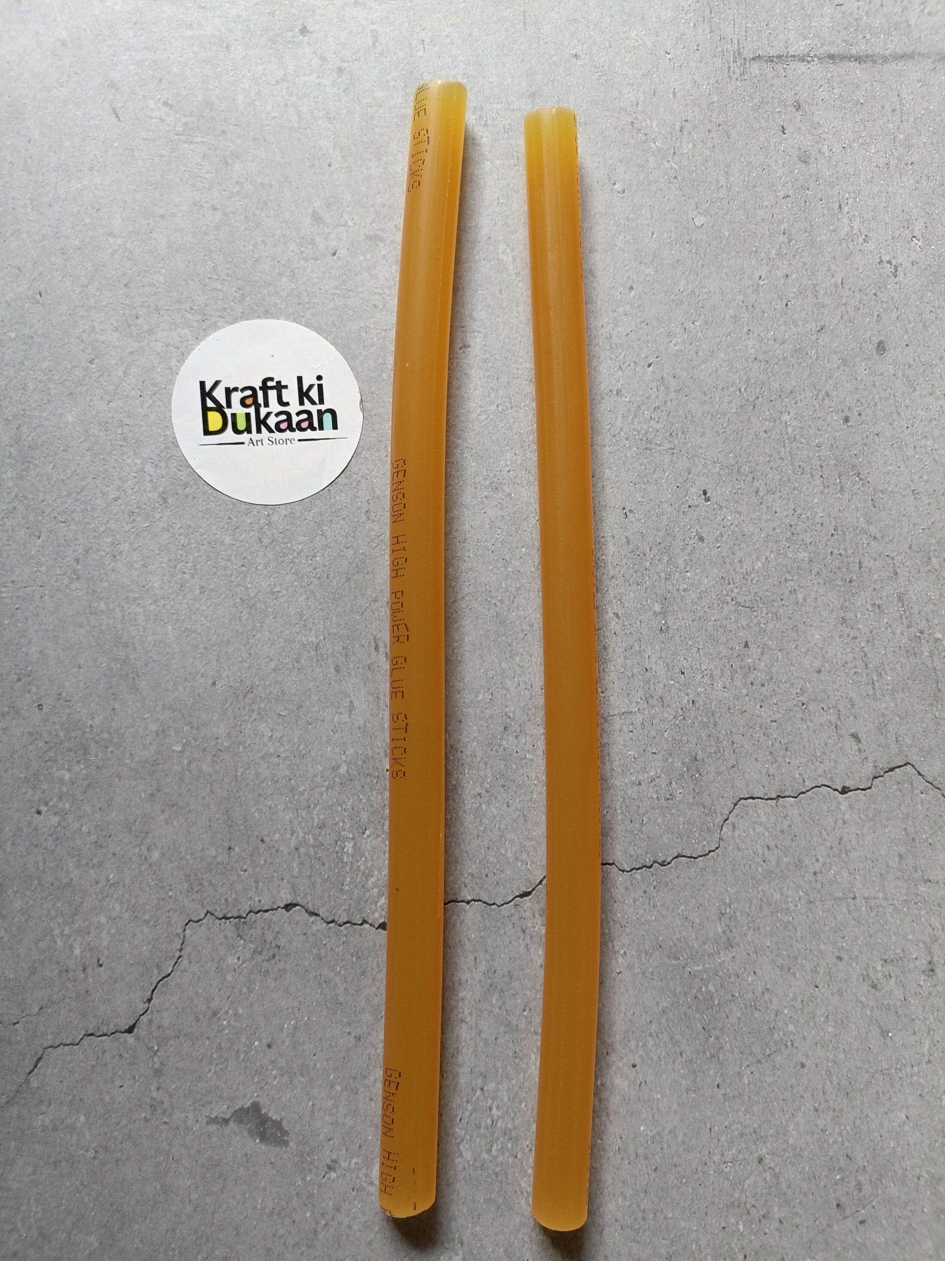 Two amber hot melt glue sticks, cylindrical with printed markings