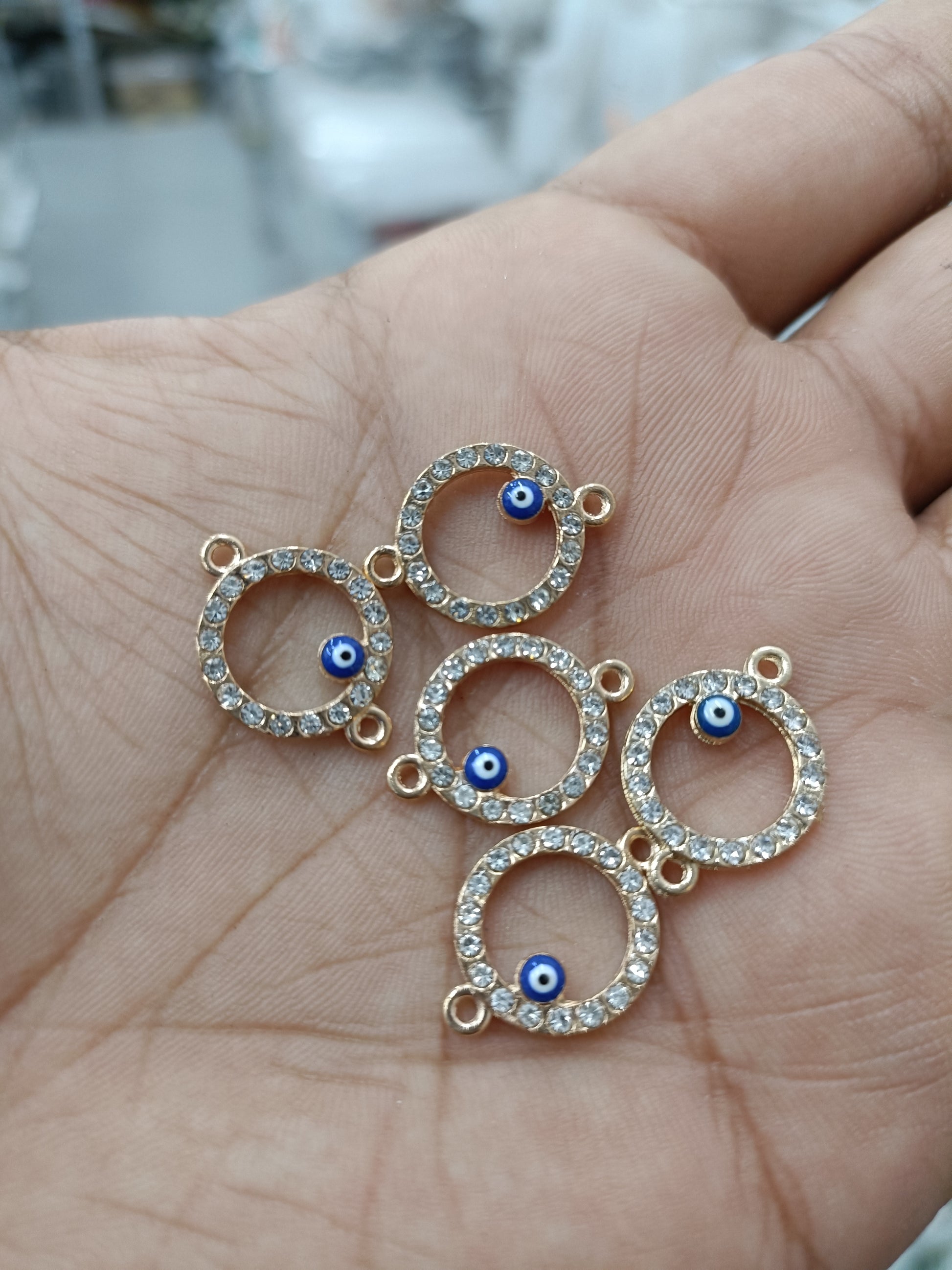 Rakhi bracelet pendant set of 5: gold-tone circular evil-eye charms with blue eye