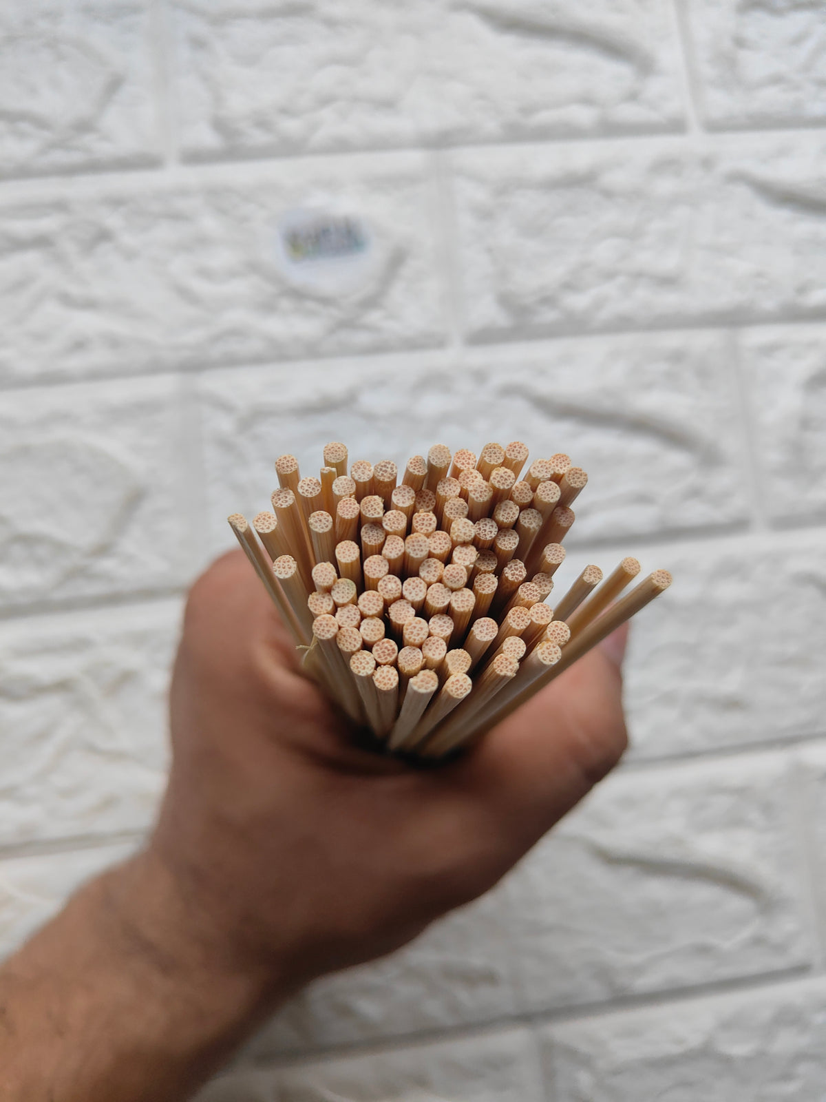 Bundle of bamboo chopsticks held in hand, textured ends with dots