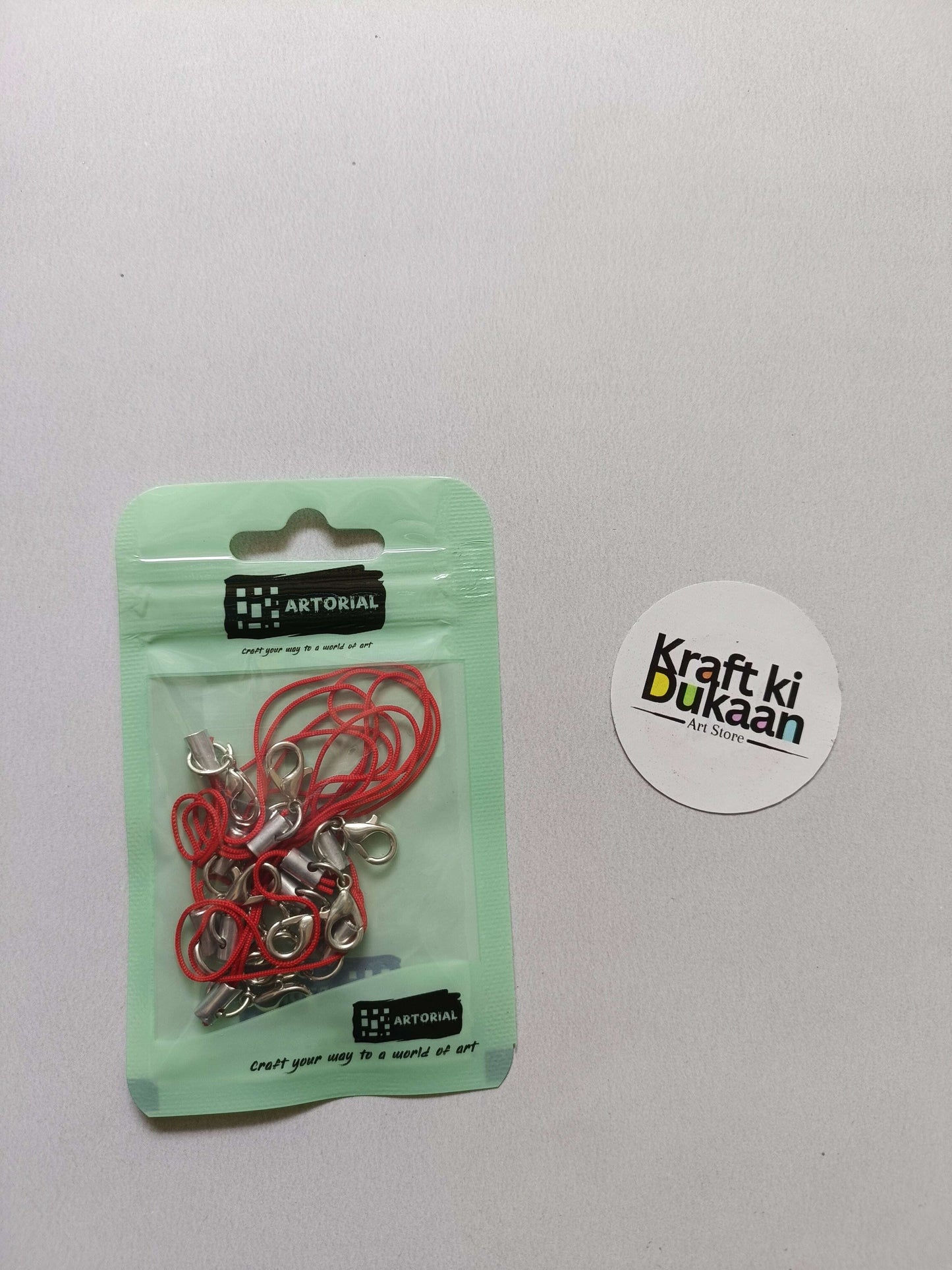 Red cord keychain set with lobster clasps, metal clips on a card pack.