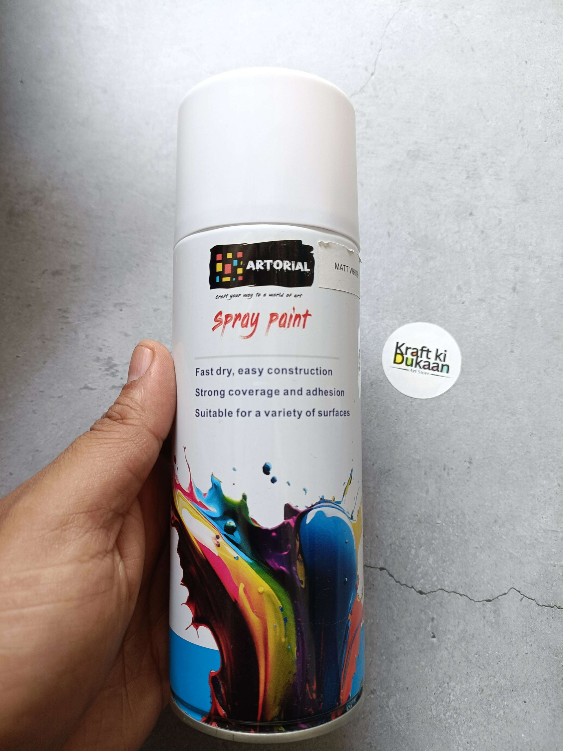 White spray paint can with colorful front label and cap