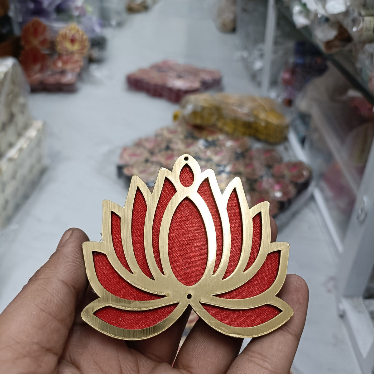 Red lotus-shaped MDF cutout with scalloped petals and beige outline, handheld view