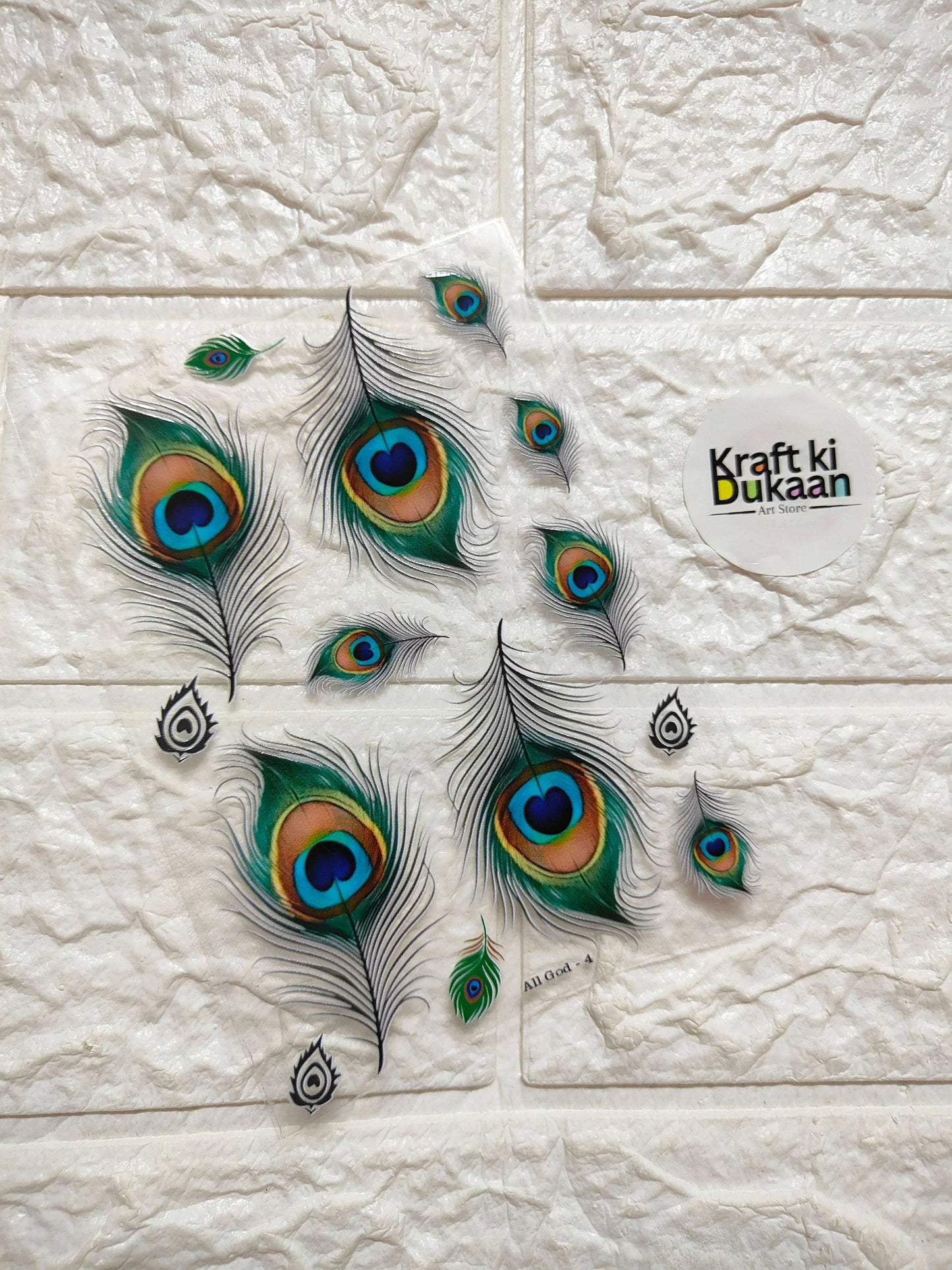 Peel-off sticker sheet with peacock feather pattern in green, teal, and blue